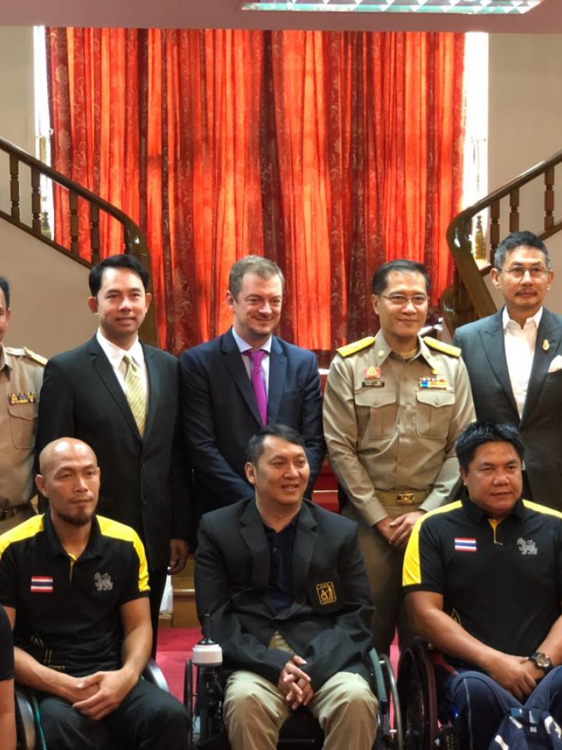 a group of officials and wheelchair athletes standing together