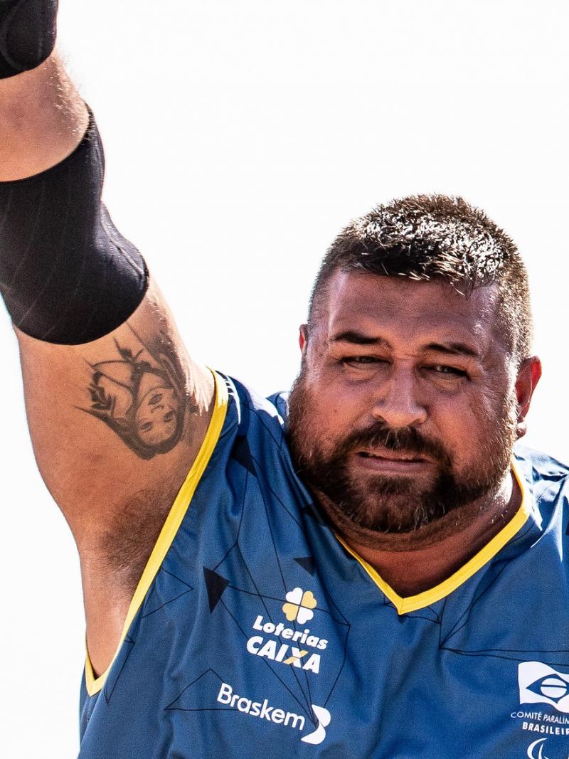 a male athlete throws a shot put