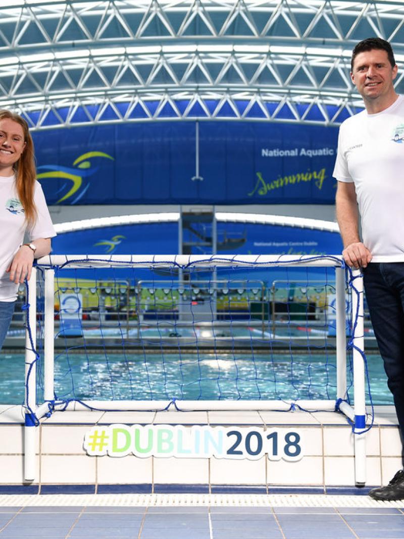 A woman and a man standing in front of a swimming pool