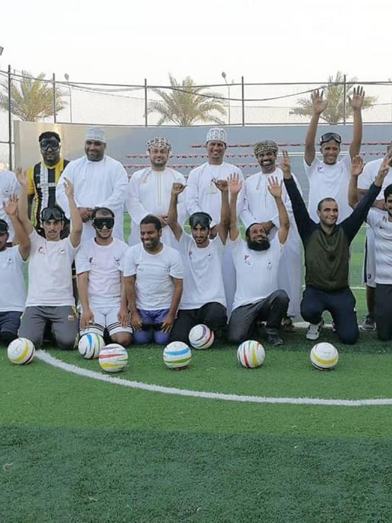 a group of blind footballers line up on a pitch