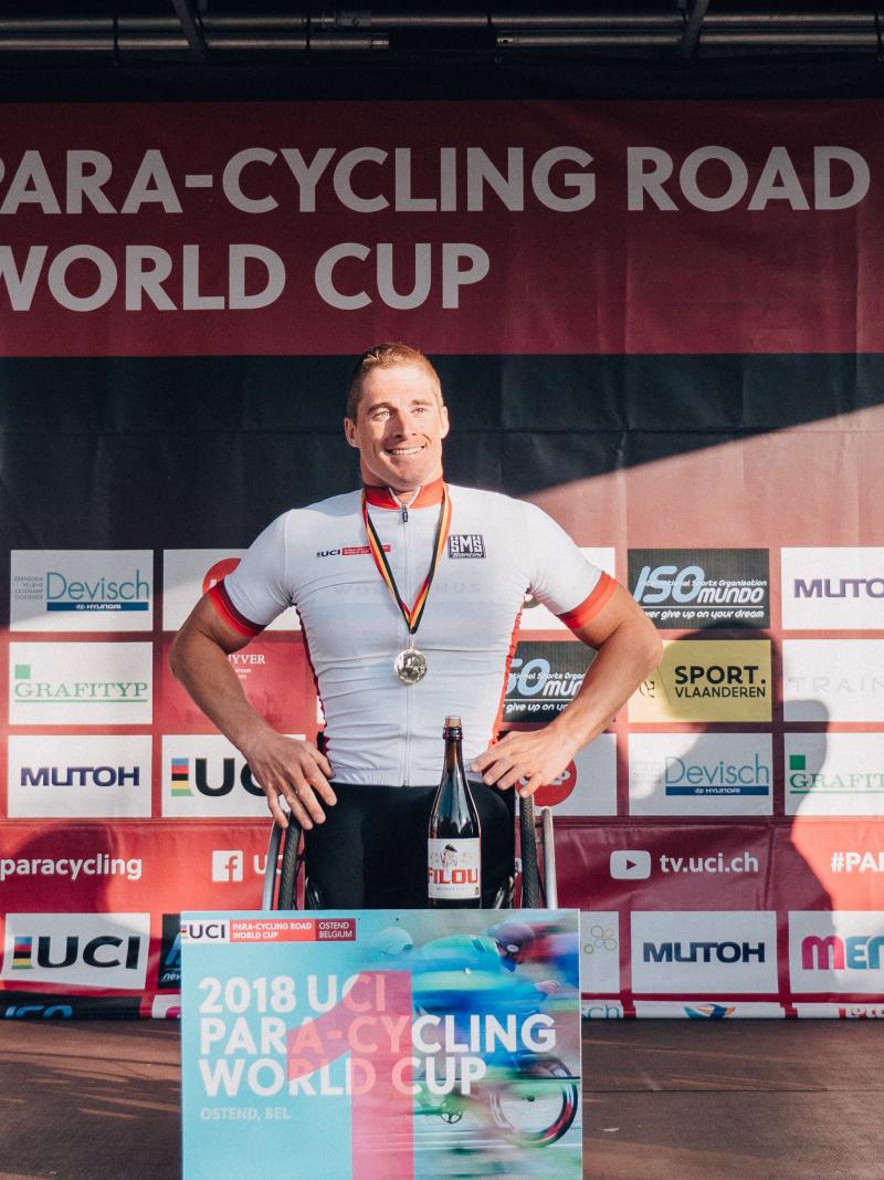 three male Para cyclists on the podium