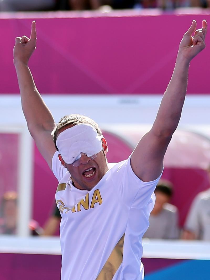 a blind footballer raises his arms in celebration