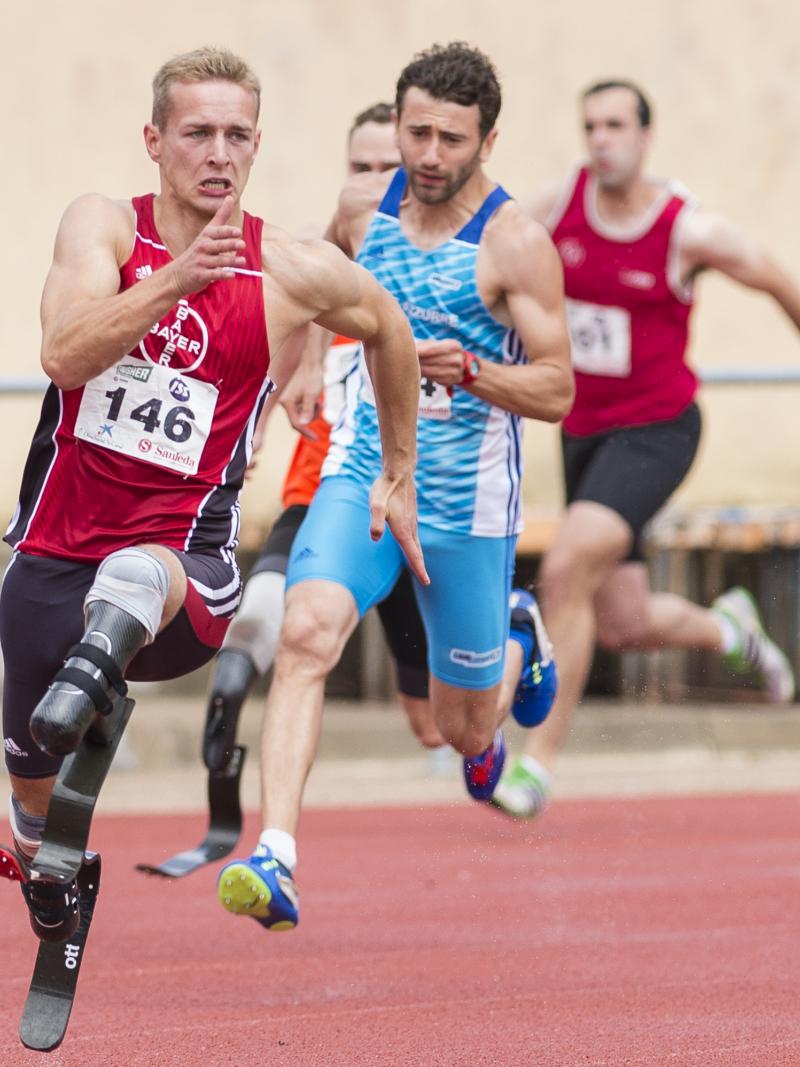 a group of male double amputee runners come round the bend
