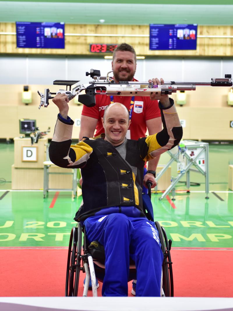 a male Para shooter and his coach celebrate 