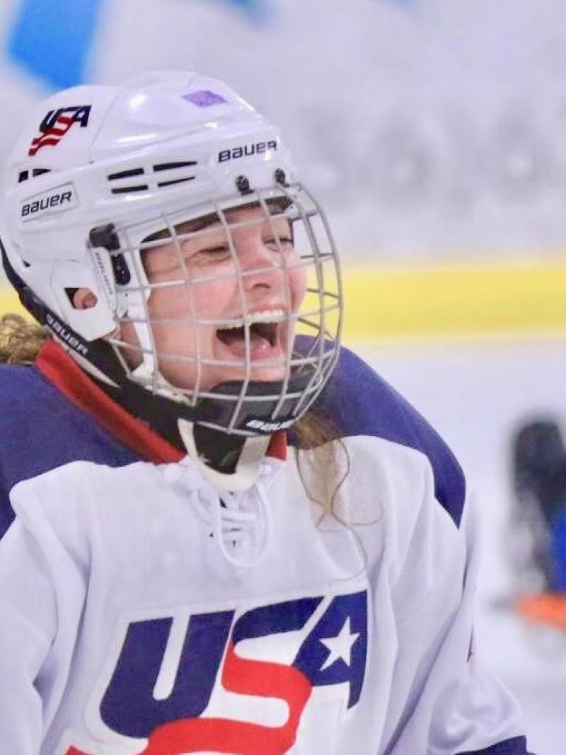 a female Para ice hockey player laughing on the ice
