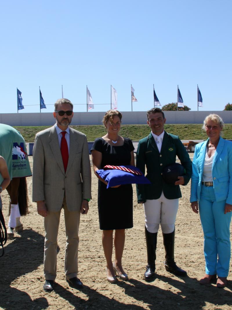 a group of people awarding a Para equestrian rider his medal