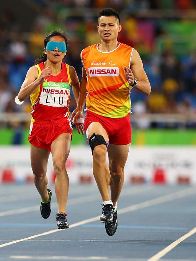 Two runners sprint towards the finish line. 