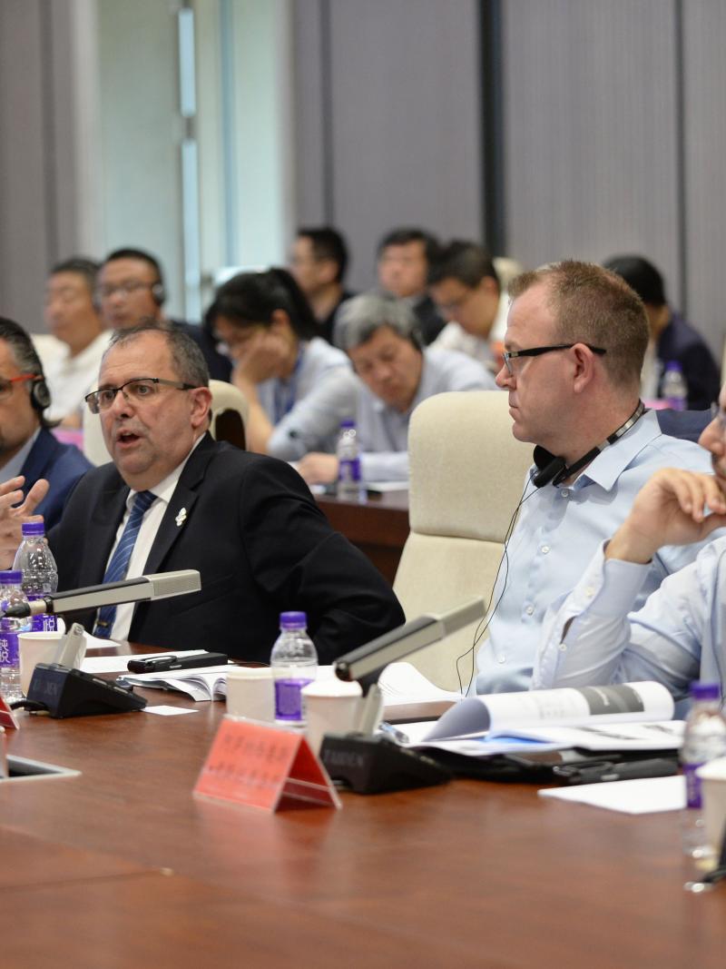 a group of men speaking at a table