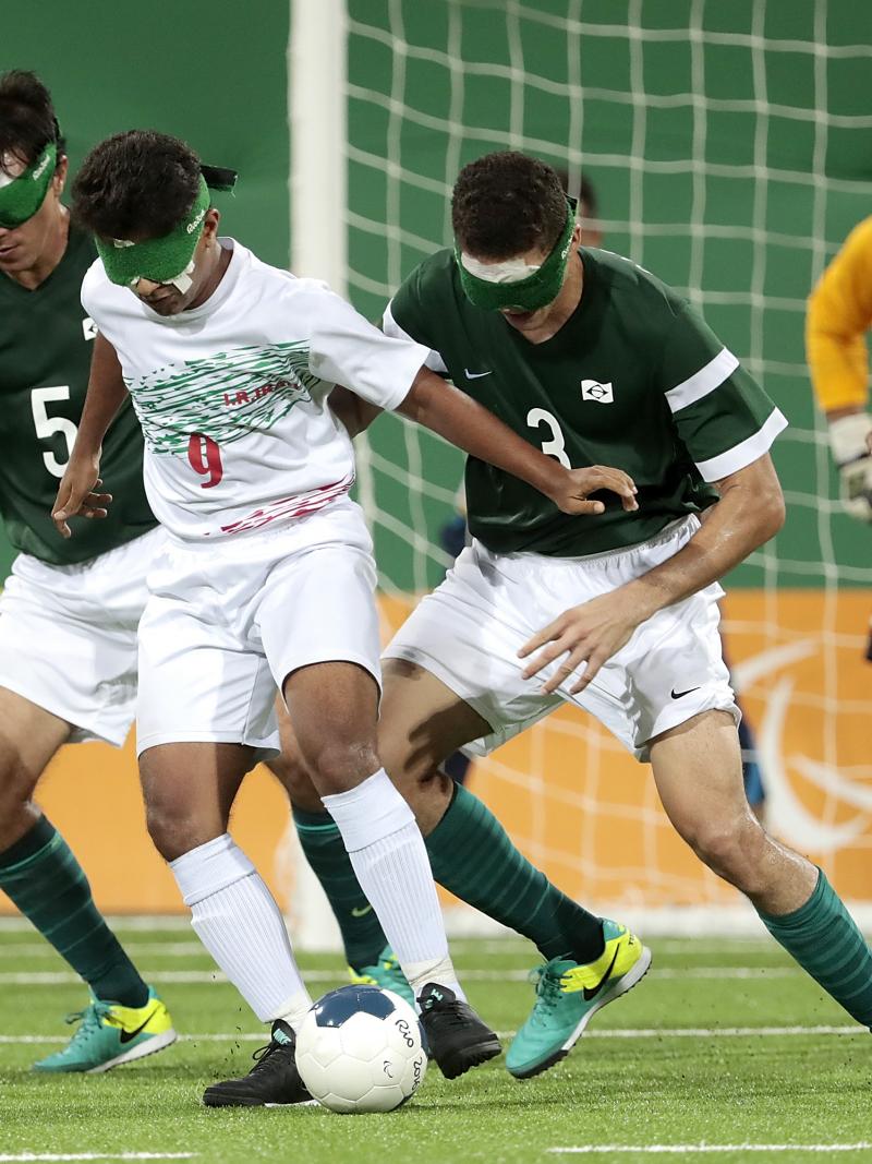 a group of blind football players in action on the pitch