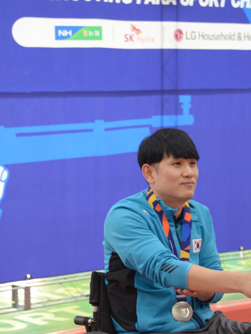 a male Para shooter receives his medal