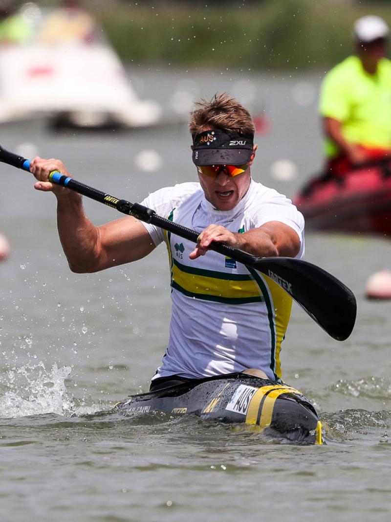 a male Para canoeist mid-stroke