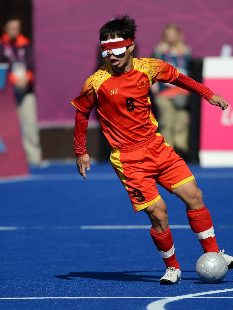 a blind football player dribbling with the ball