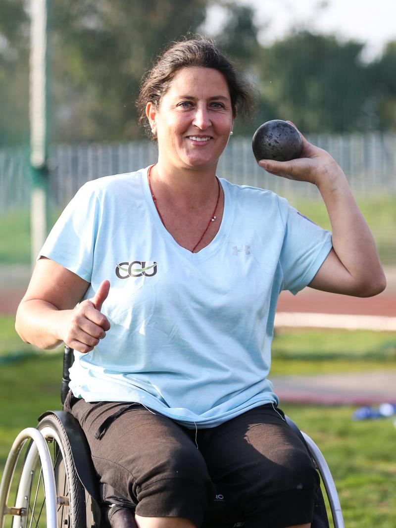 a female Para athlete prepares to throw a shot put