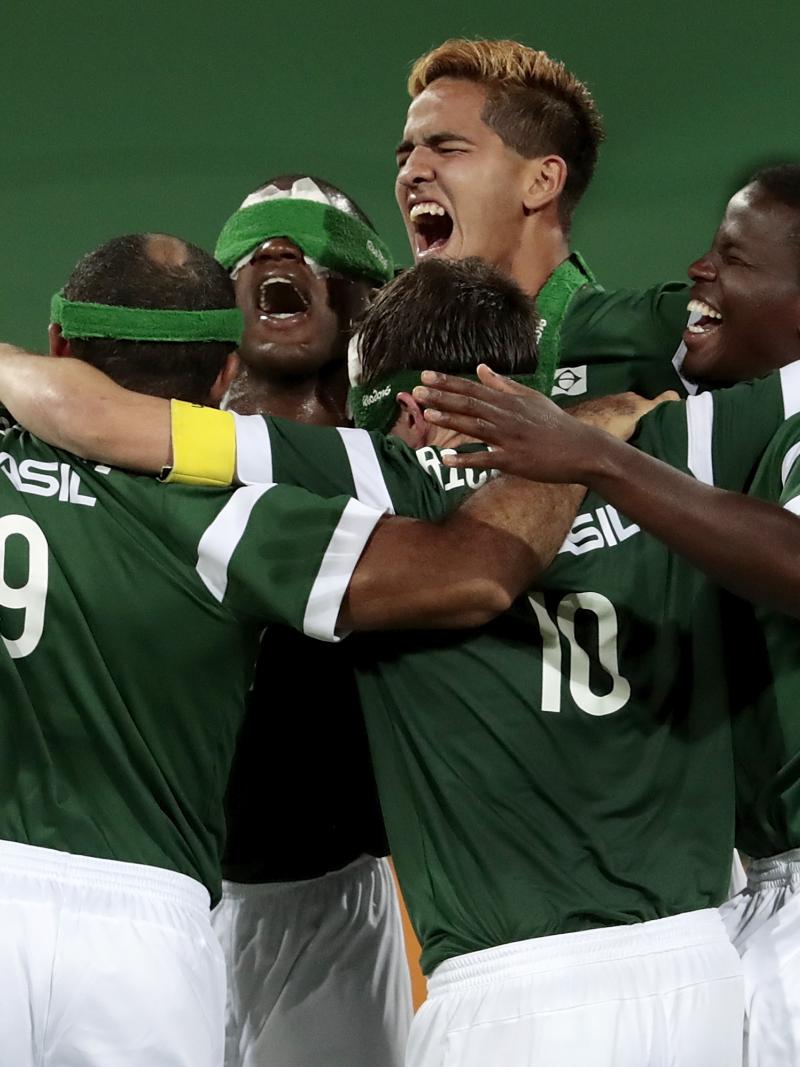 Five Brazilian blind football players celebrating