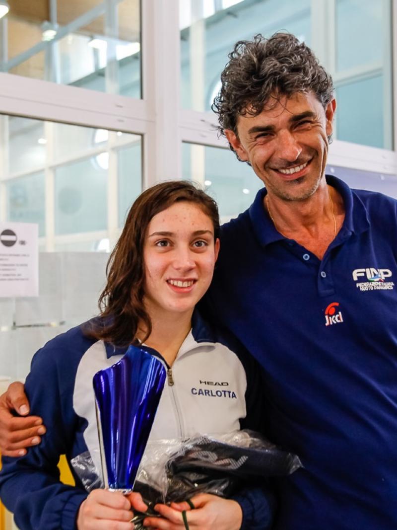 a female Para swimmer is hugged by her coach