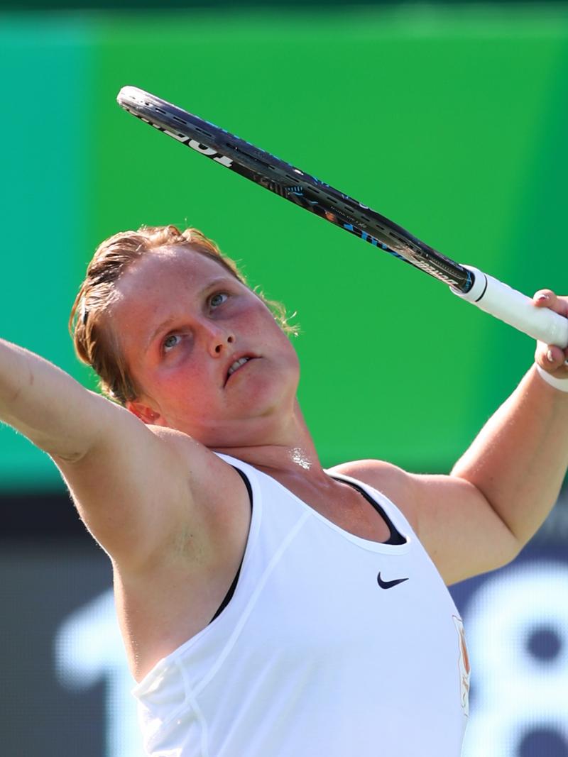 a female wheelchair tennis player prepares to serve