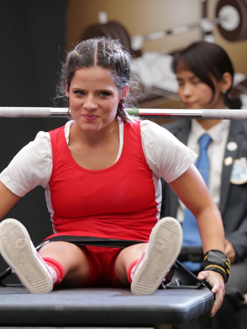 a female powerlifter smiling on the bench
