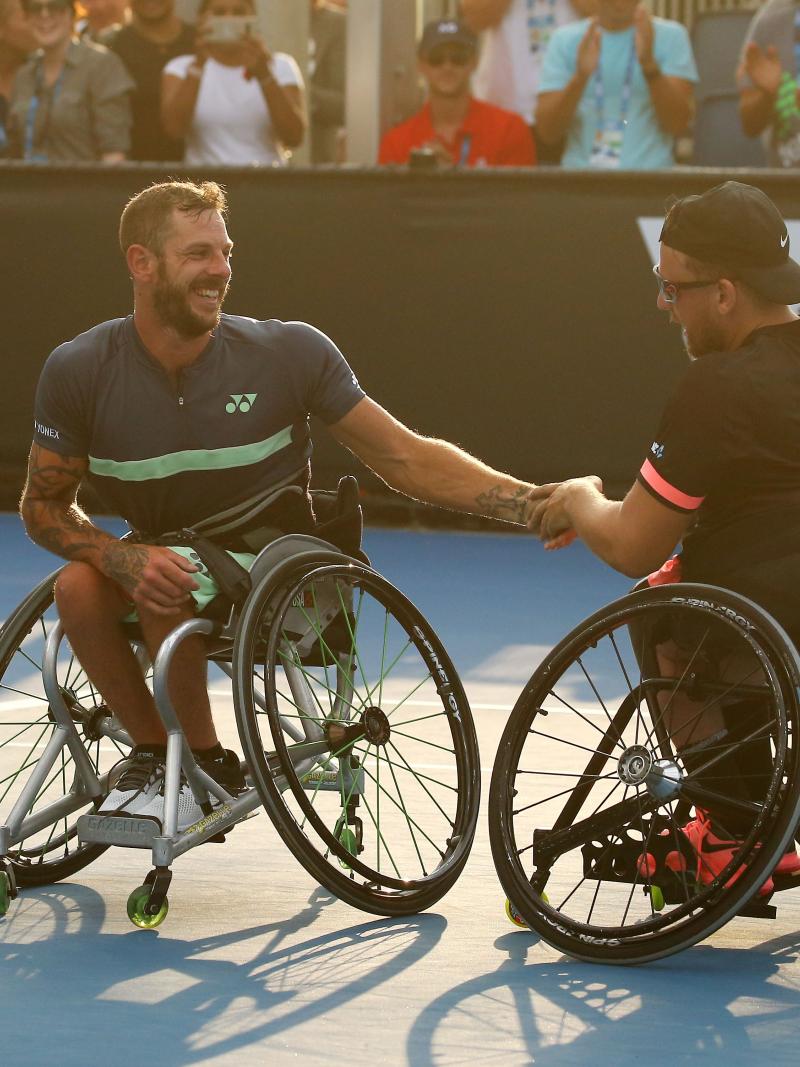 Two men in wheelchairs shake hands