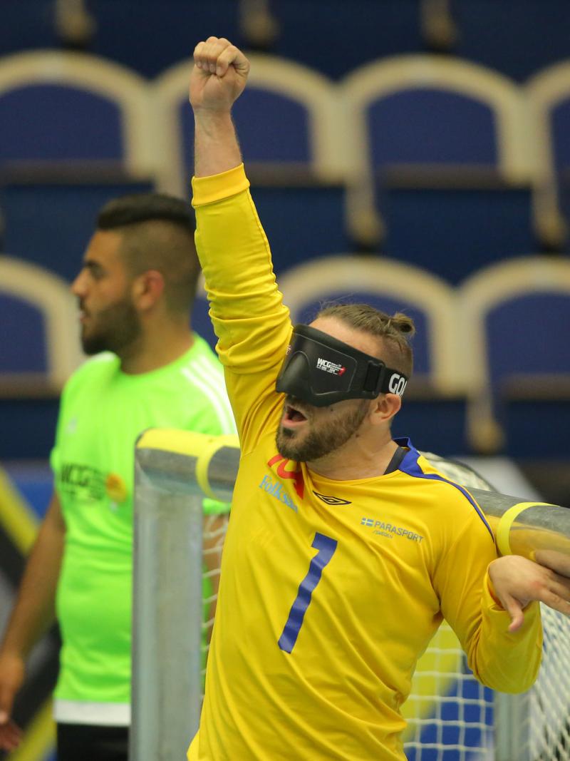 a male goalball player punches the air in celebration