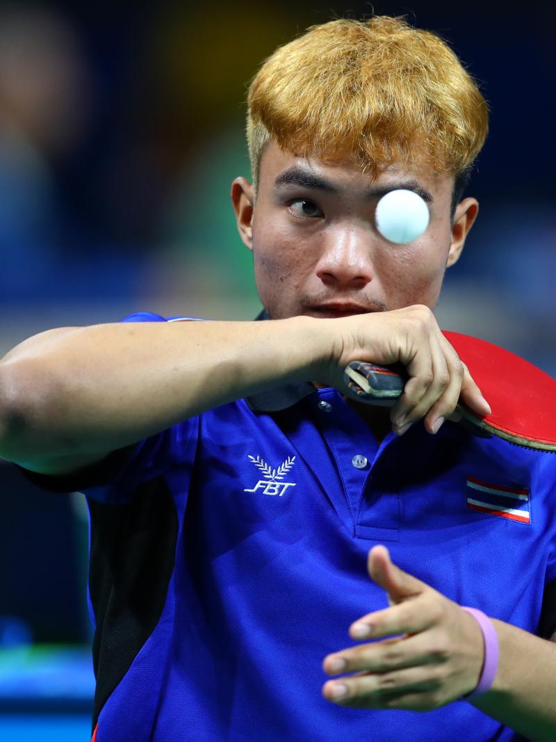 Man trying to hit a table tennis ball