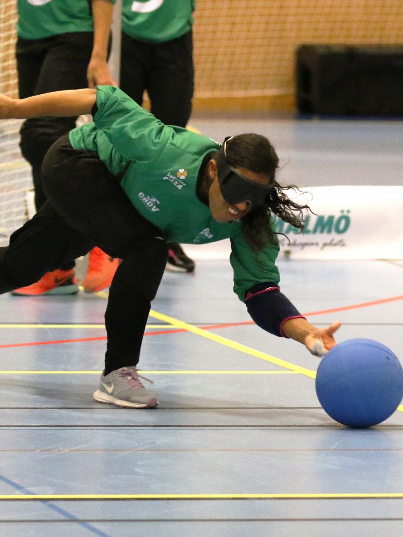 a female goalball player throws the ball