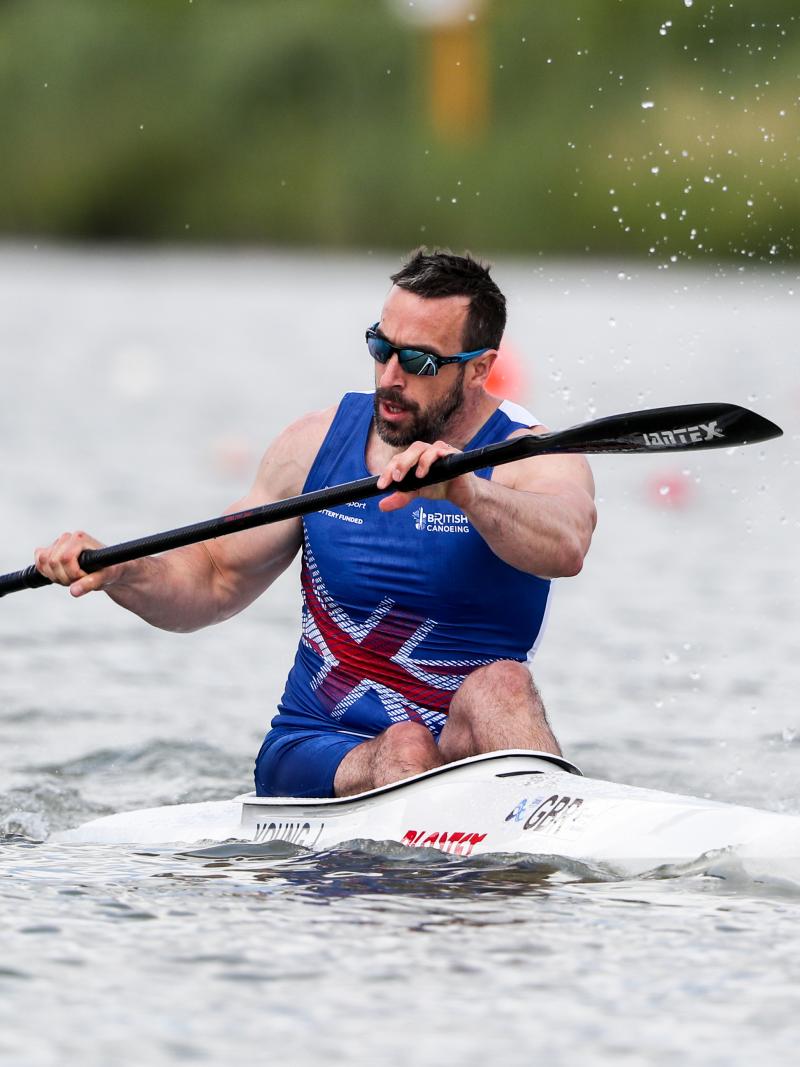 a male canoeist paddles on the water