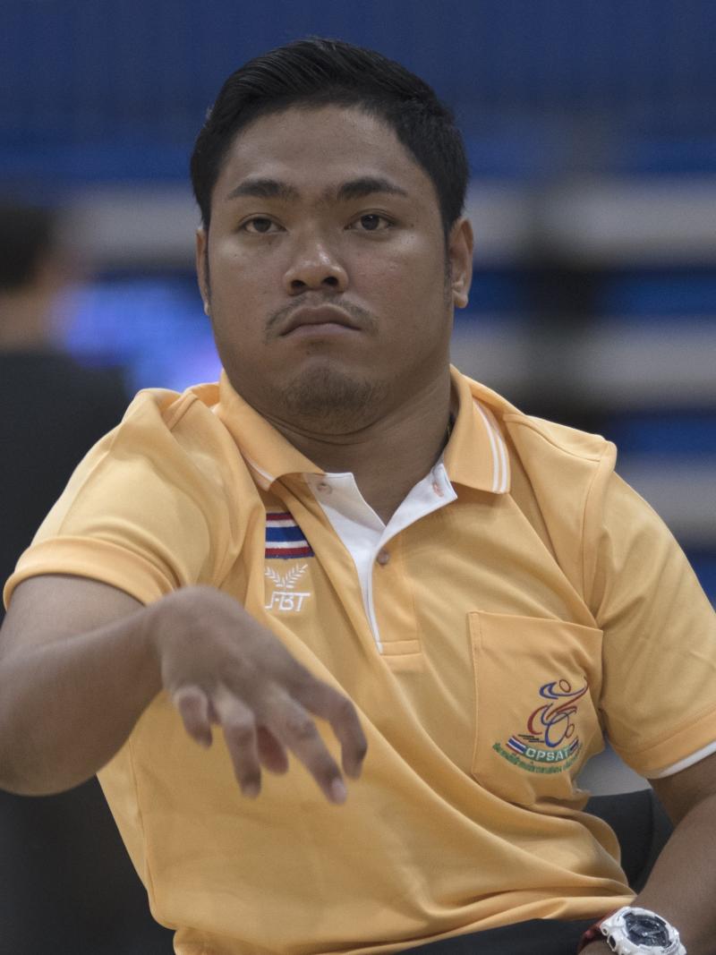 a male boccia player throws a ball