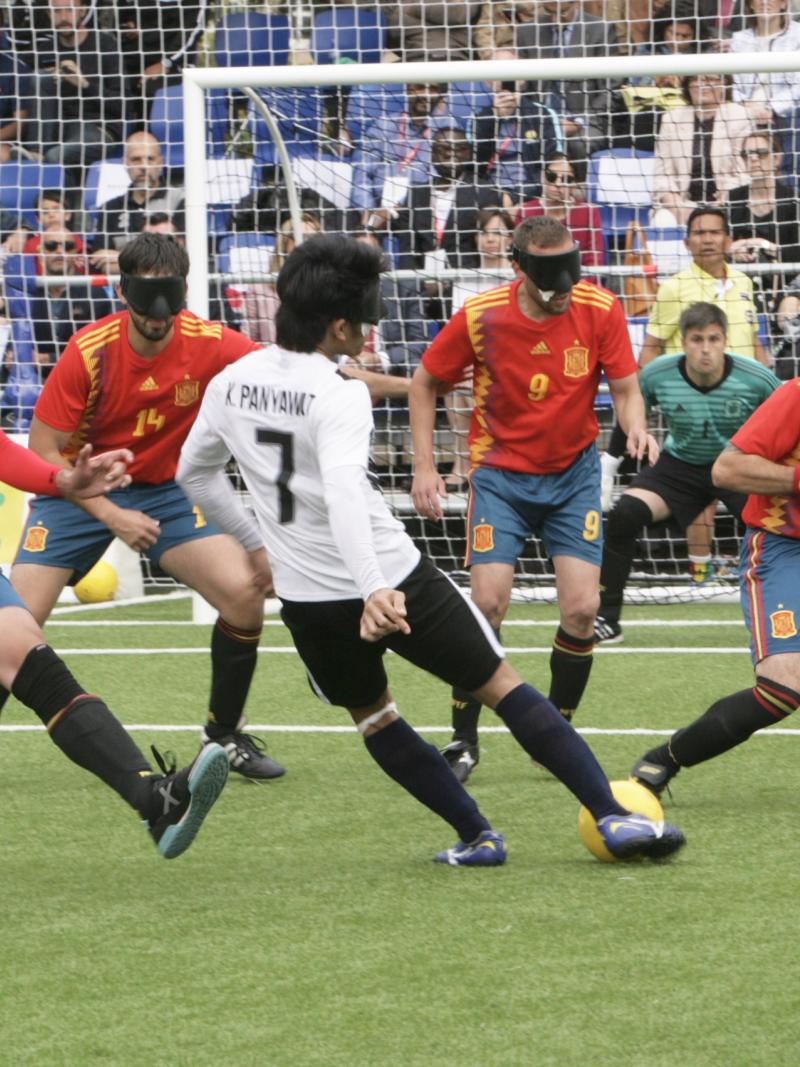 a group of blind footballers in action on the pitch