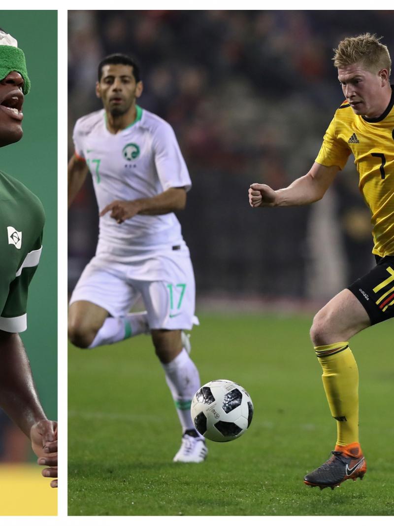 a male blind football player and a male able-bodied footballer dribbling with the ball