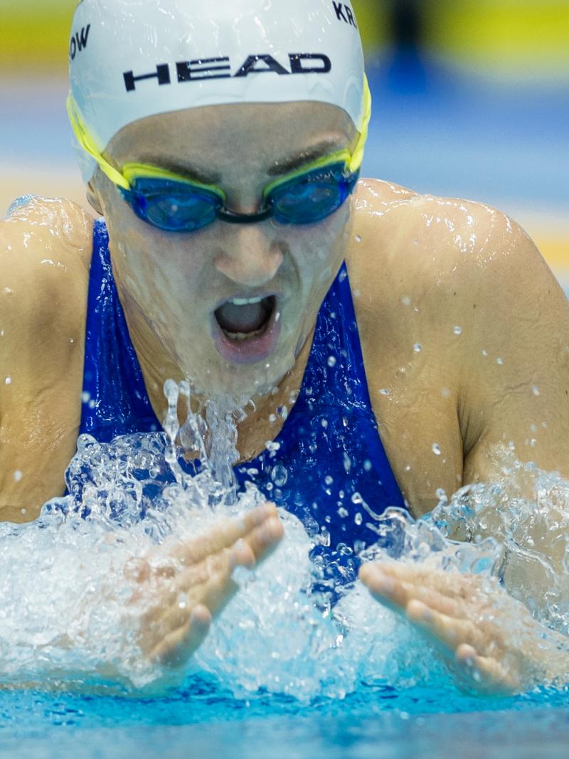 a female Para swimmer takes a breath during breaststroke