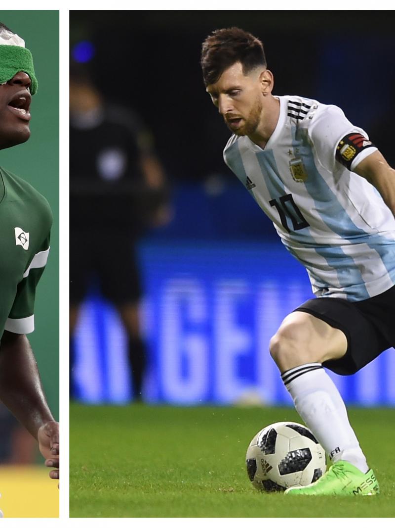 a male blind footballer and a male able-bodied footballer on the pitch