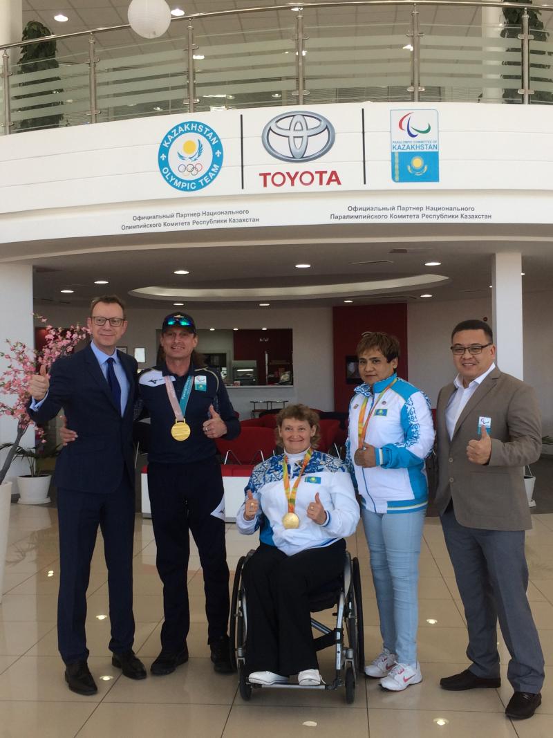 a group of people standing in front of a Toyota sign