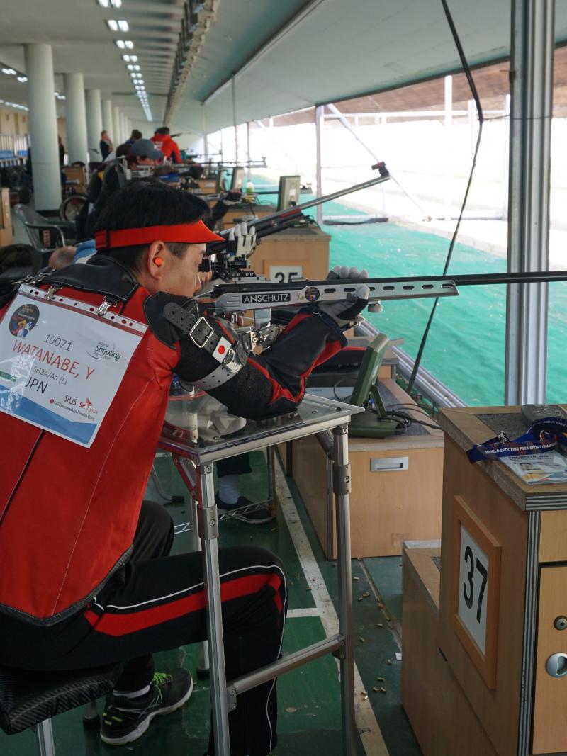 a male Para shooter takes a shot with a rifle