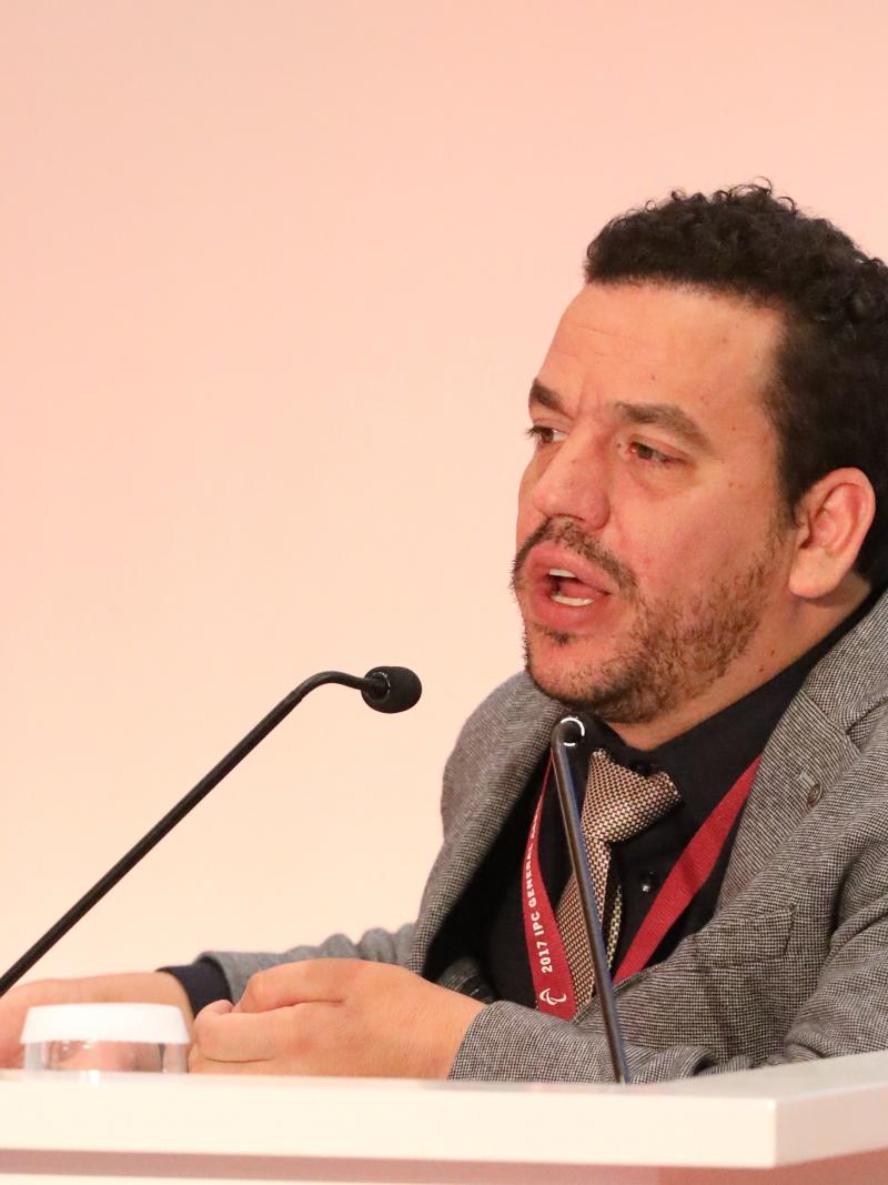 a man speaking into a microphone at a podium
