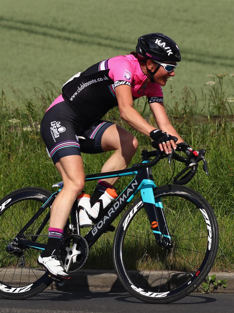 a female Para cyclist rides down a road