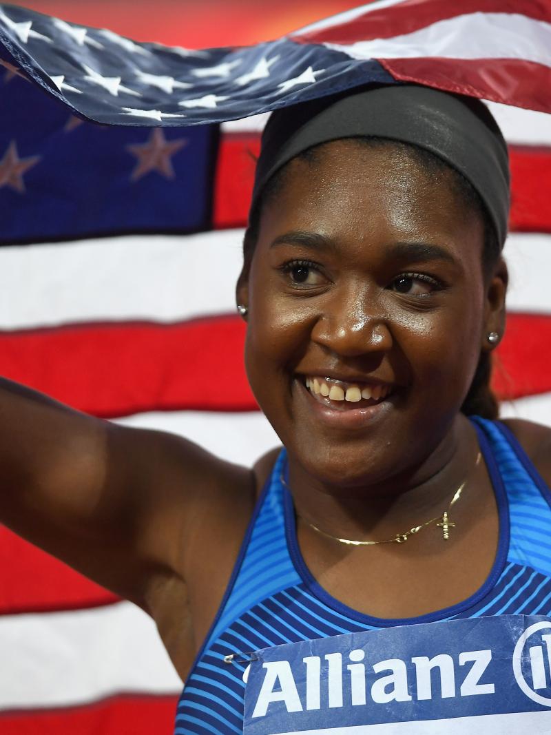 a female Para athlete smiling and holding an American flag