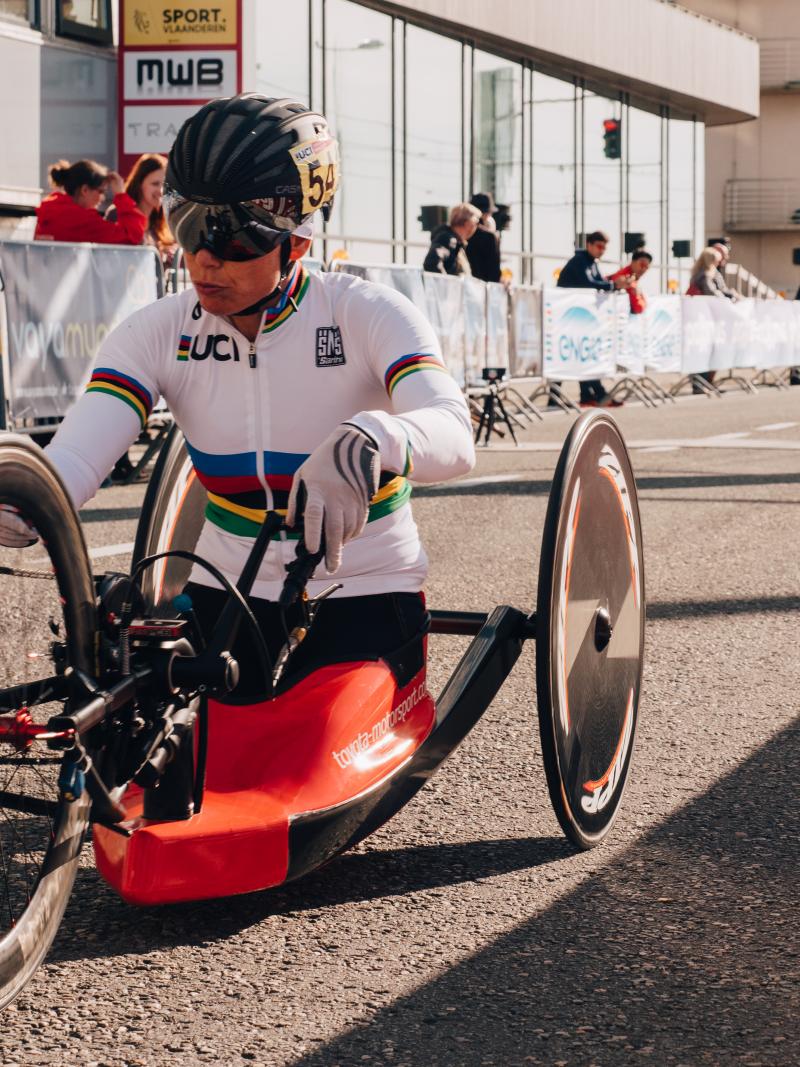 a female hand-cyclist begins a road race