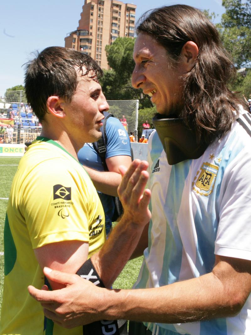 two blind footballers hugging on the pitch
