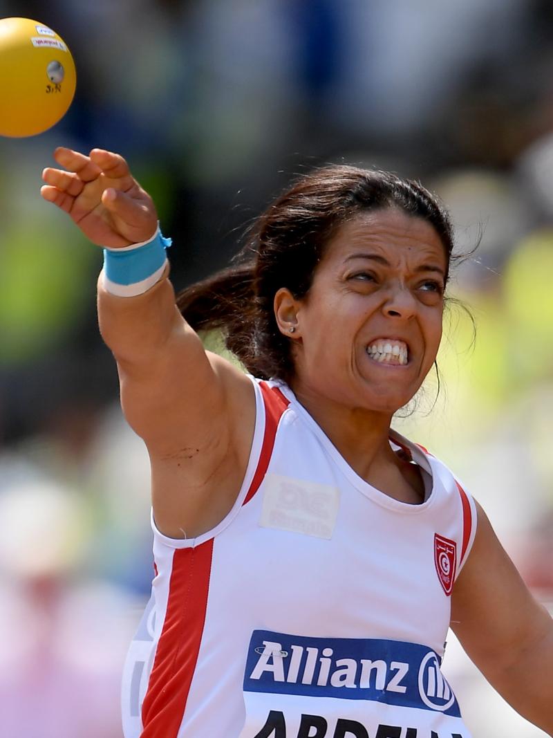 a female Para athlete of short stature throws a shot put