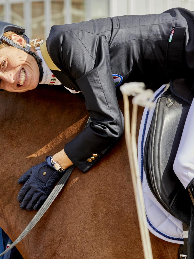 a female Para equestrian rider hugging her horse