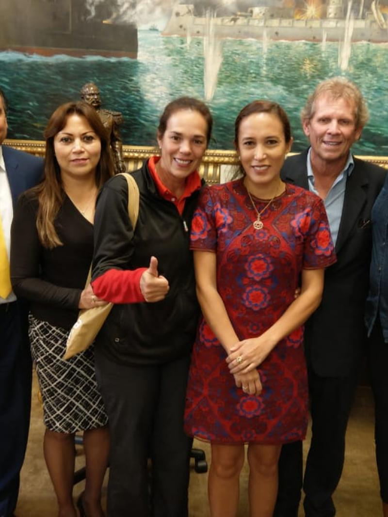a group of people in a government office smiling at the camera
