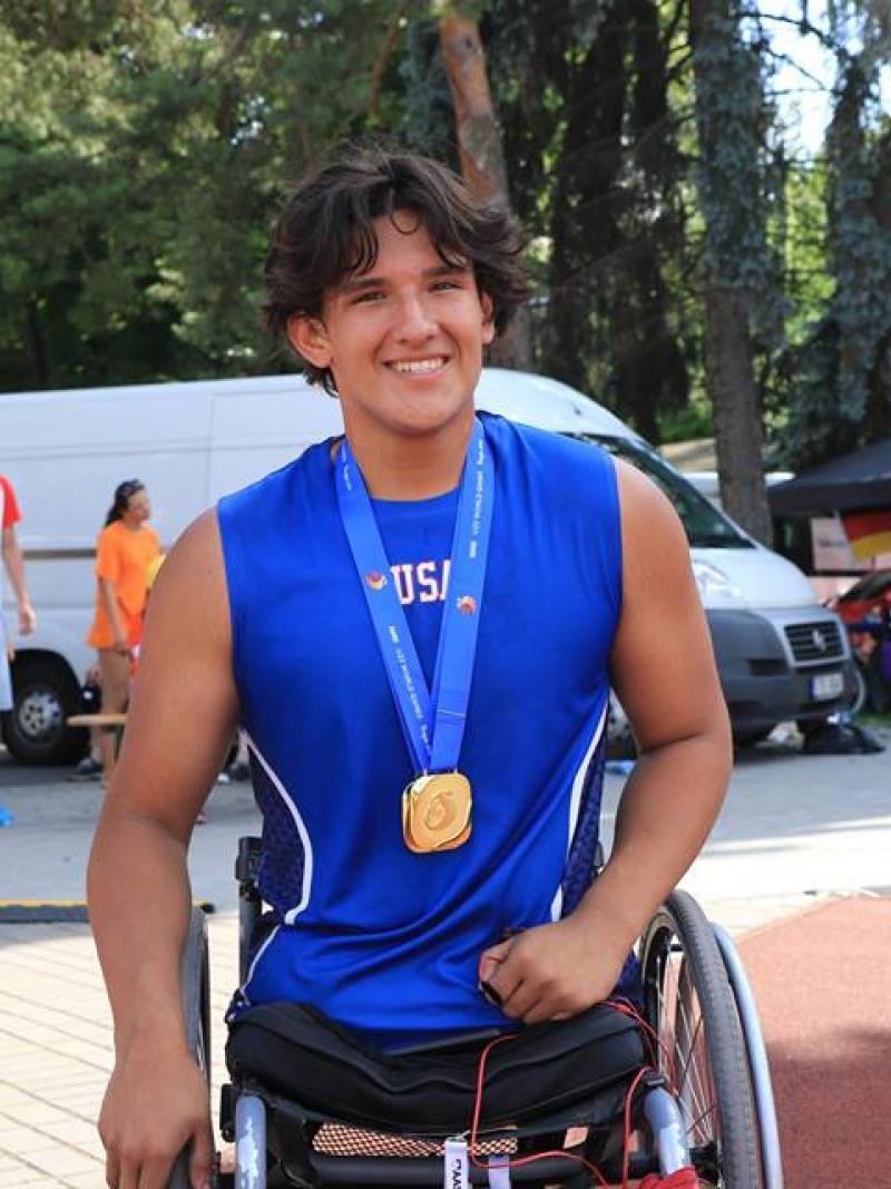 a male wheelchair athlete smiles for the camera