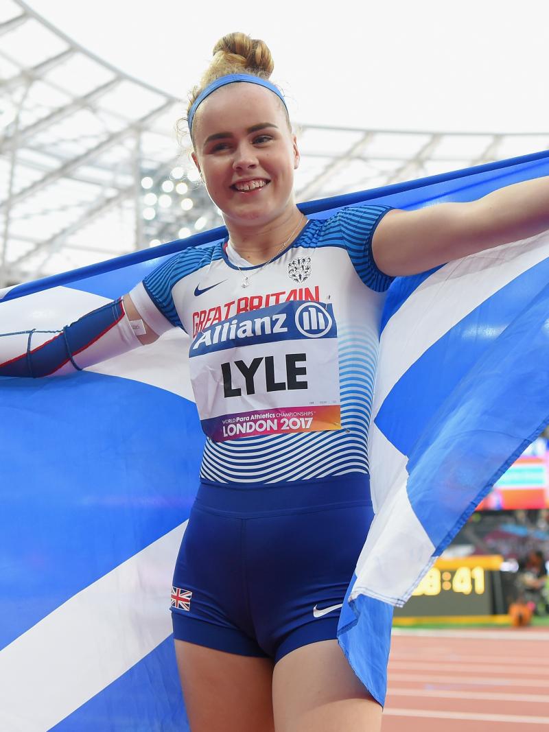 A female Para sprinter holding up a Scotland flag
