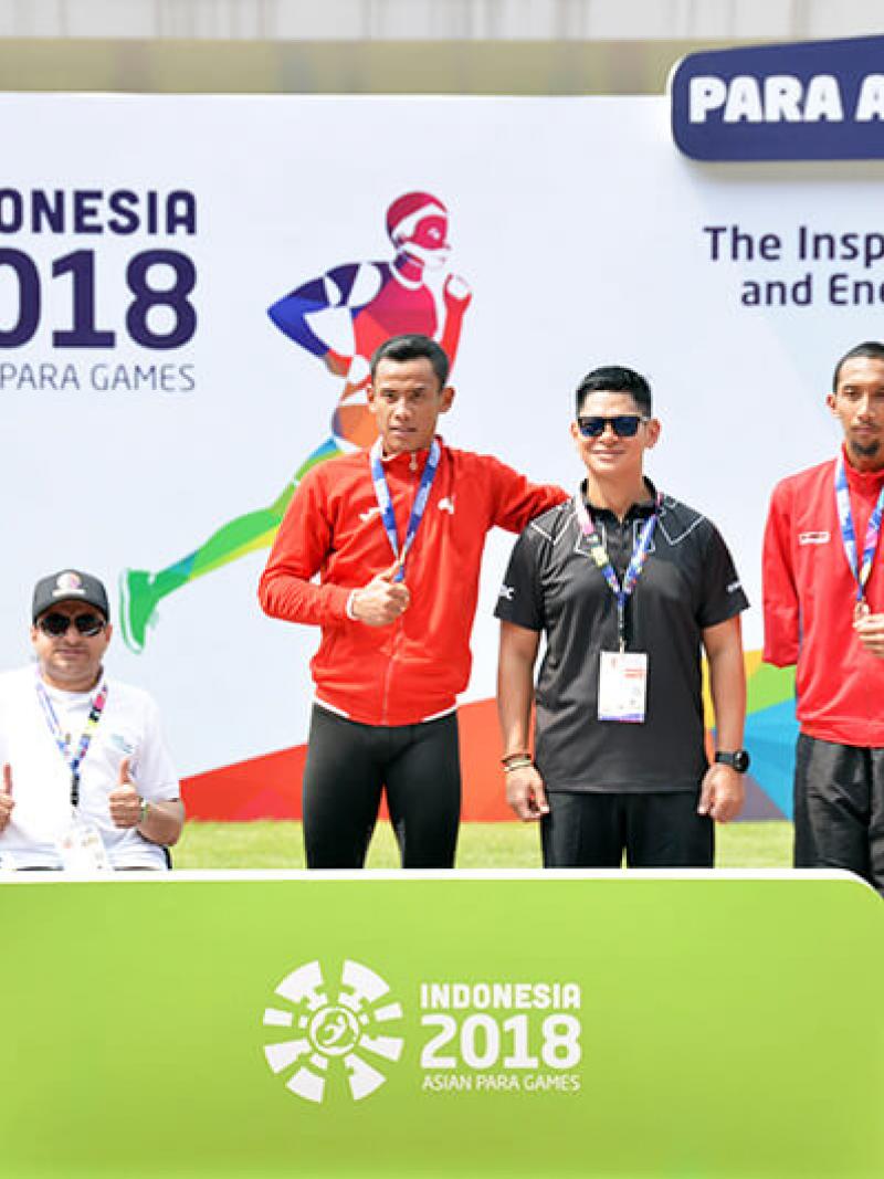 Athletes and their guides pose on the podium