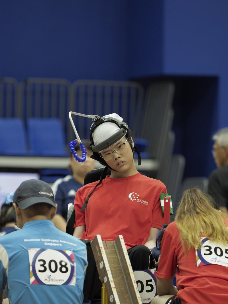 Boccia athlete Toh Sze Ning and her assistant get ready to roll ball down ramp