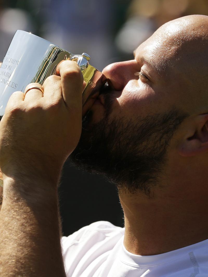 Men holding and kissing a small trophy