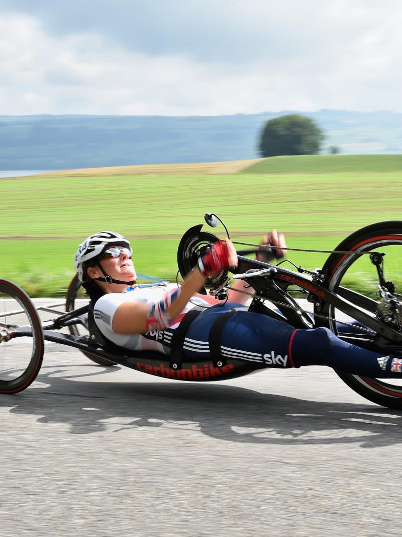 female British Para cyclist Karen Darke racing with a hand-bike on a road