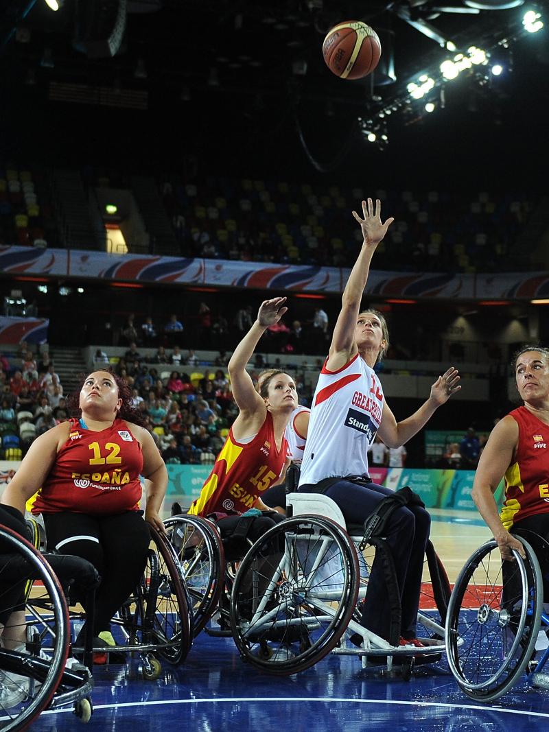 a group of female Spanish wheelchair basketballers fighting for the ball on the court