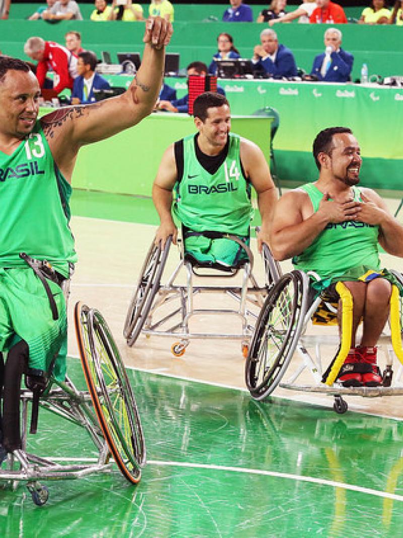 Three Brazilian men wheelchair basketball players wave at home crowd