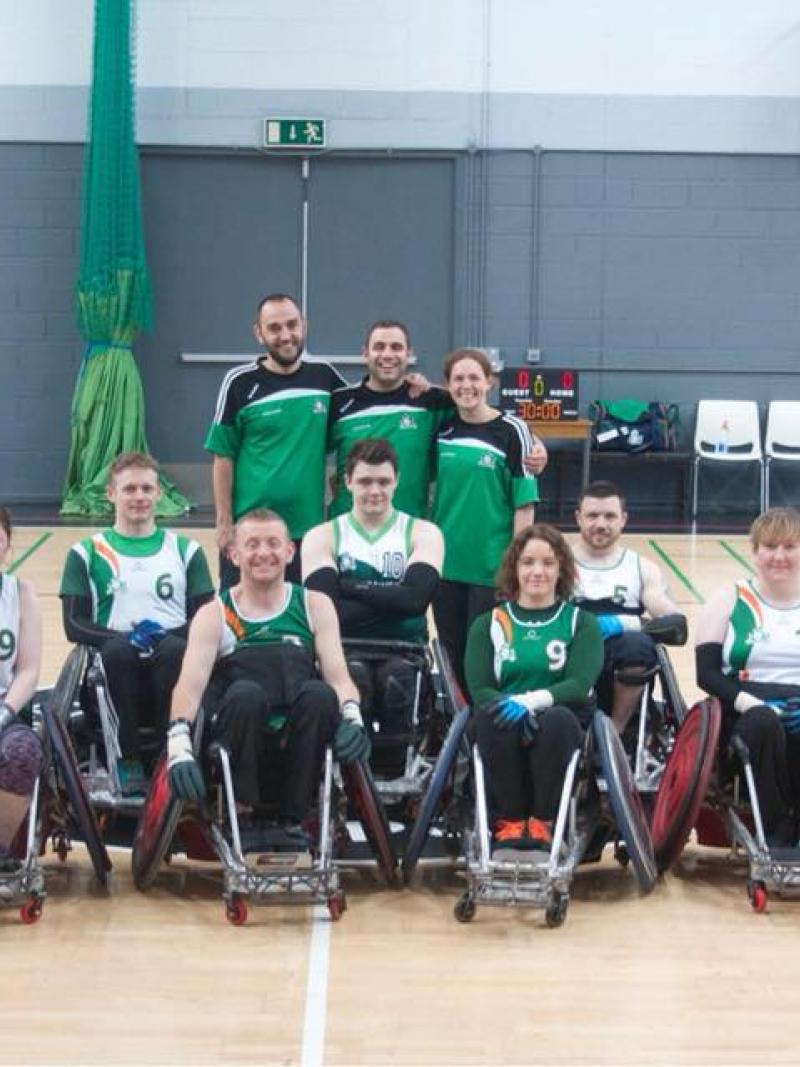 the Ireland male and female wheelchair rugby team smiling on a court